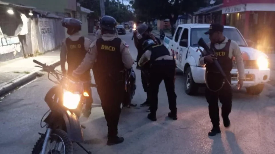 Agentes de la DNCD en una calle del sector Villa Flores, provincia San Juan, junto a una camioneta y una motocicleta de la institución, durante el operativo en el que fue arrestado «King Kong»