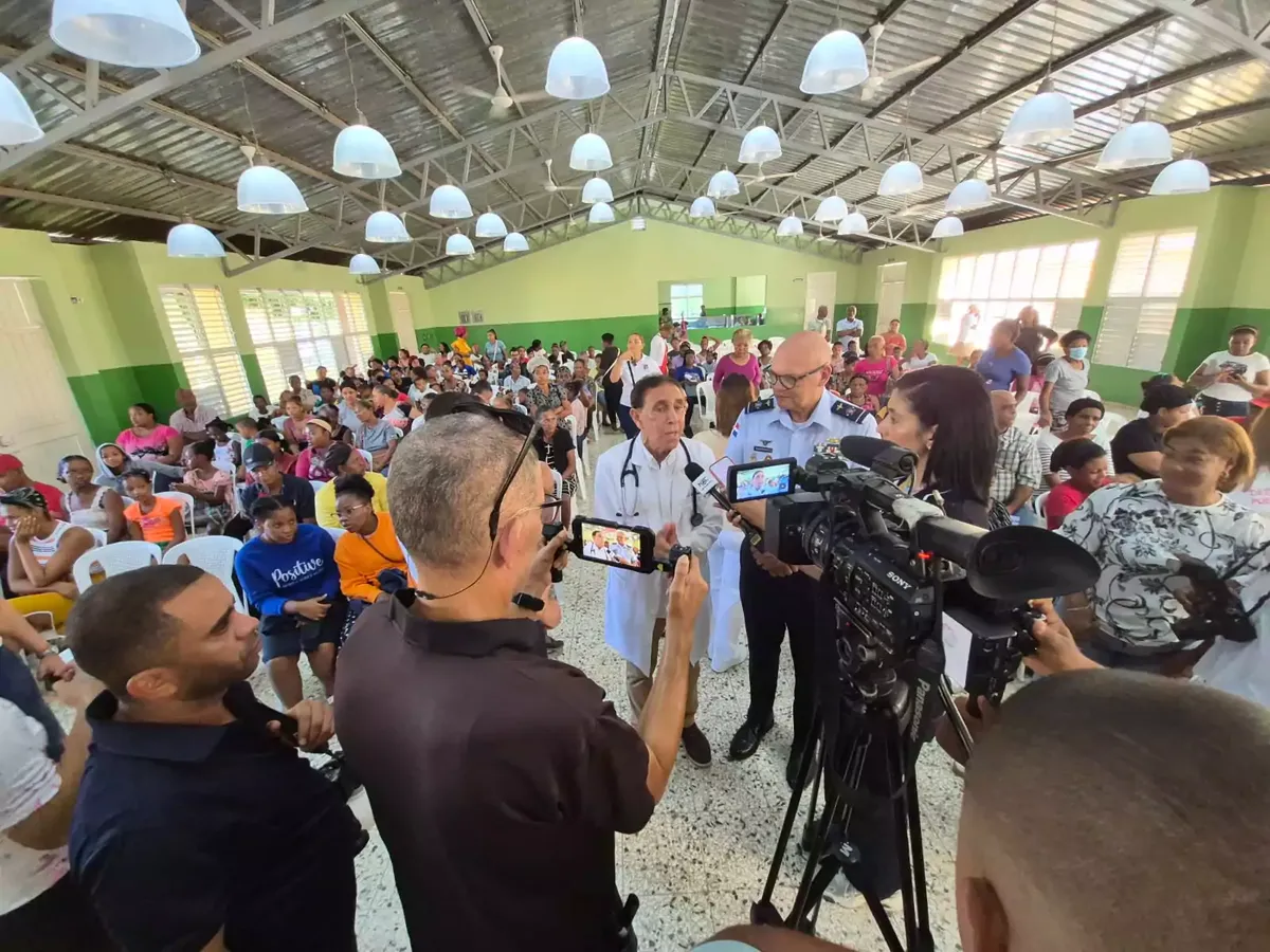 El doctor Félix Antonio Cruz Jiminián y el jefe de la Fuerza Aérea Dominicana atienden a la prensa ante cientos de residentes de El Bonito, San Isidro, durante el operativo médico conjunto